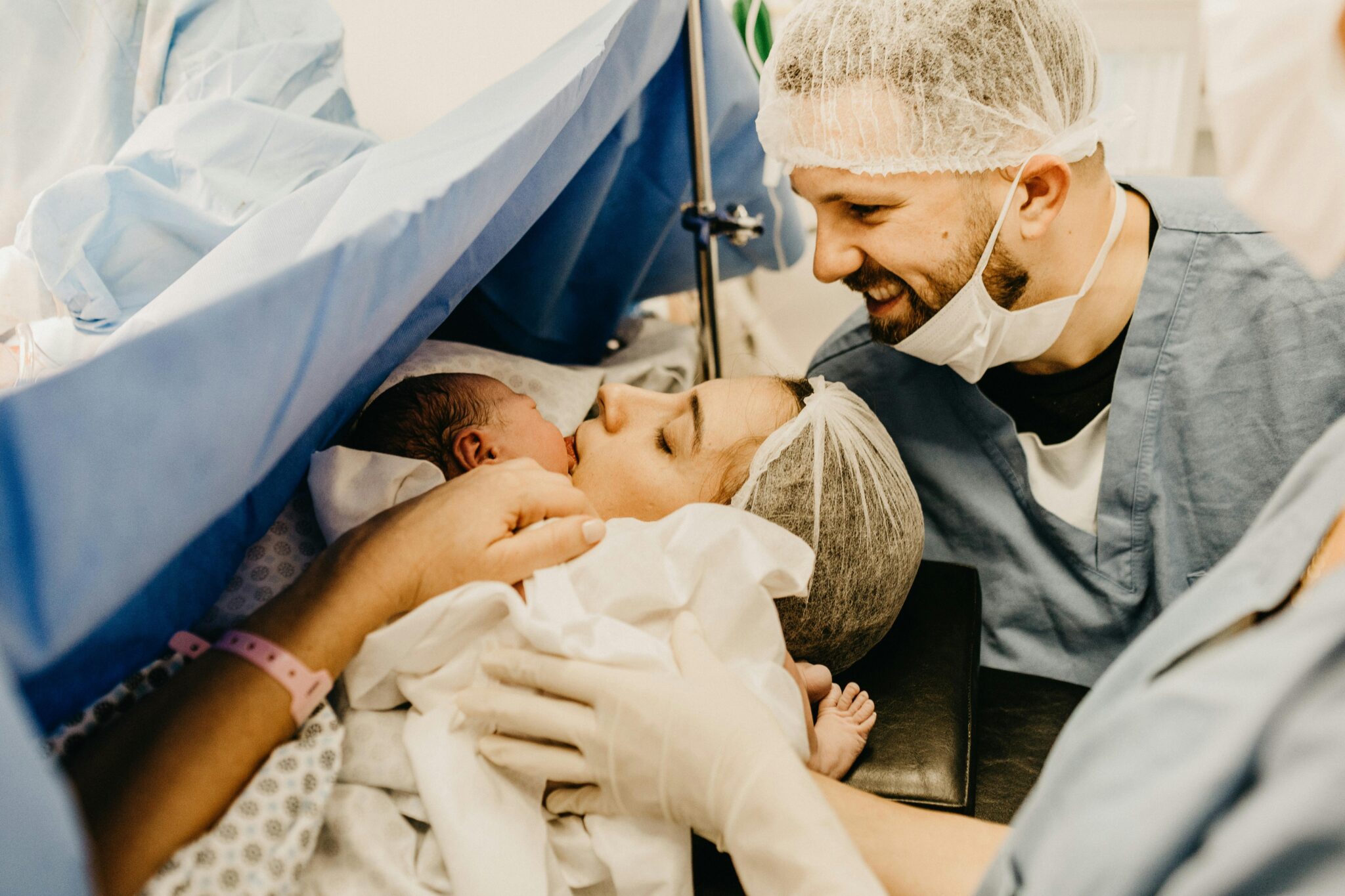 A cherished family moment as new parents welcome their baby in a hospital delivery room.